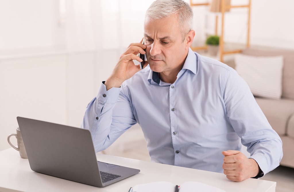uomo pensieroso al telefono
